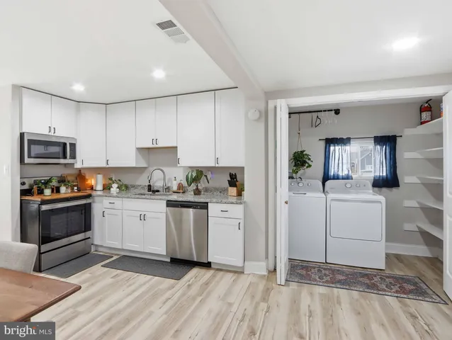 a kitchen with granite countertop cabinets stainless steel appliances and a counter space