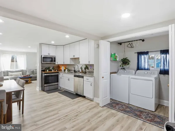 a kitchen with white cabinets and appliances
