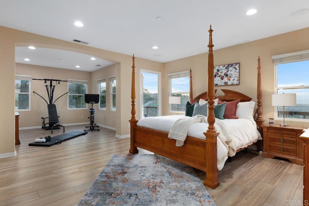 979 Canyon Heights San Marcos, CA 92078 - Photo 27 of 58 a bedroom with a bed and large mirror with wooden floor