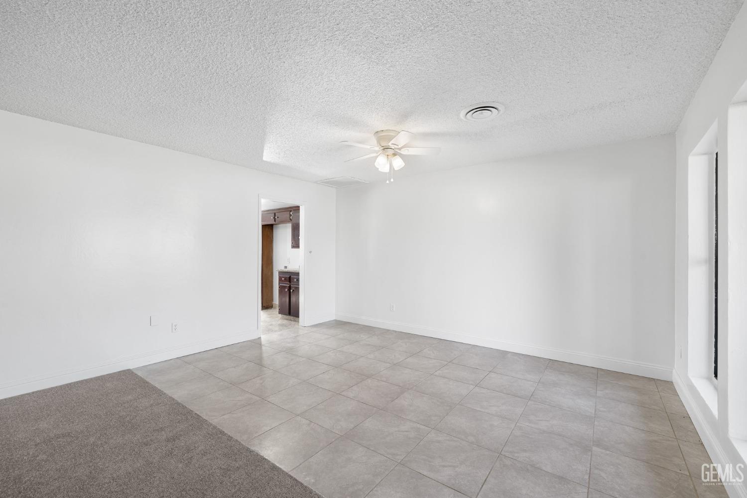 Undisclosed Address Bakersfield, CA 93309 - Photo 12 of 59 an empty room with an entryway and fan