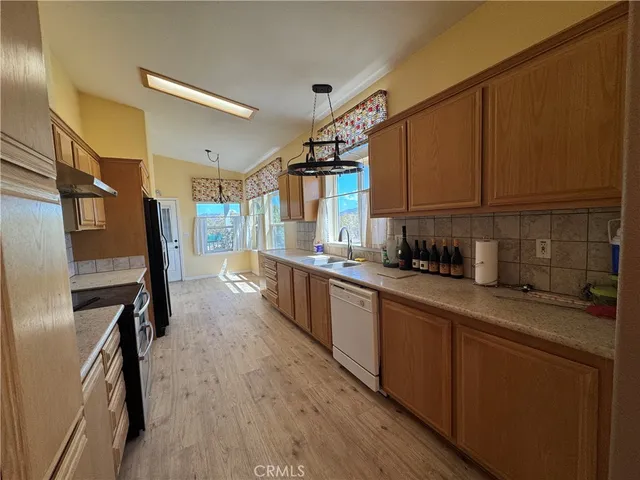 a kitchen with stainless steel appliances a refrigerator a sink a stove and cabinets