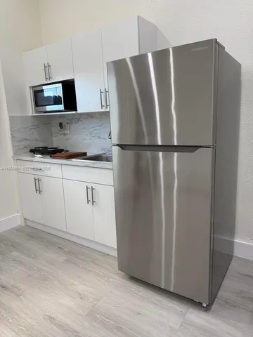 a kitchen with stainless steel appliances a refrigerator a sink a stove a microwave a counter top space and cabinets