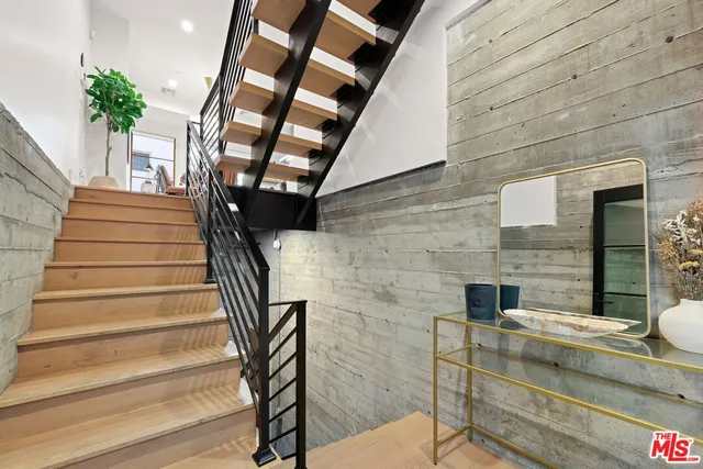 a kitchen with stainless steel appliances kitchen island granite countertop a sink dishwasher a dining table and chairs with wooden floor