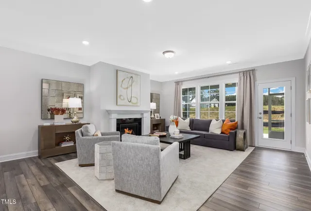a living room with furniture large window and wooden floor