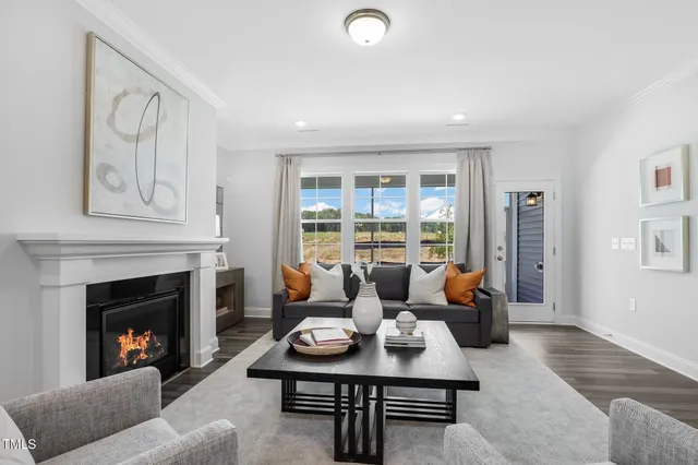 a living room with furniture fireplace and a large window