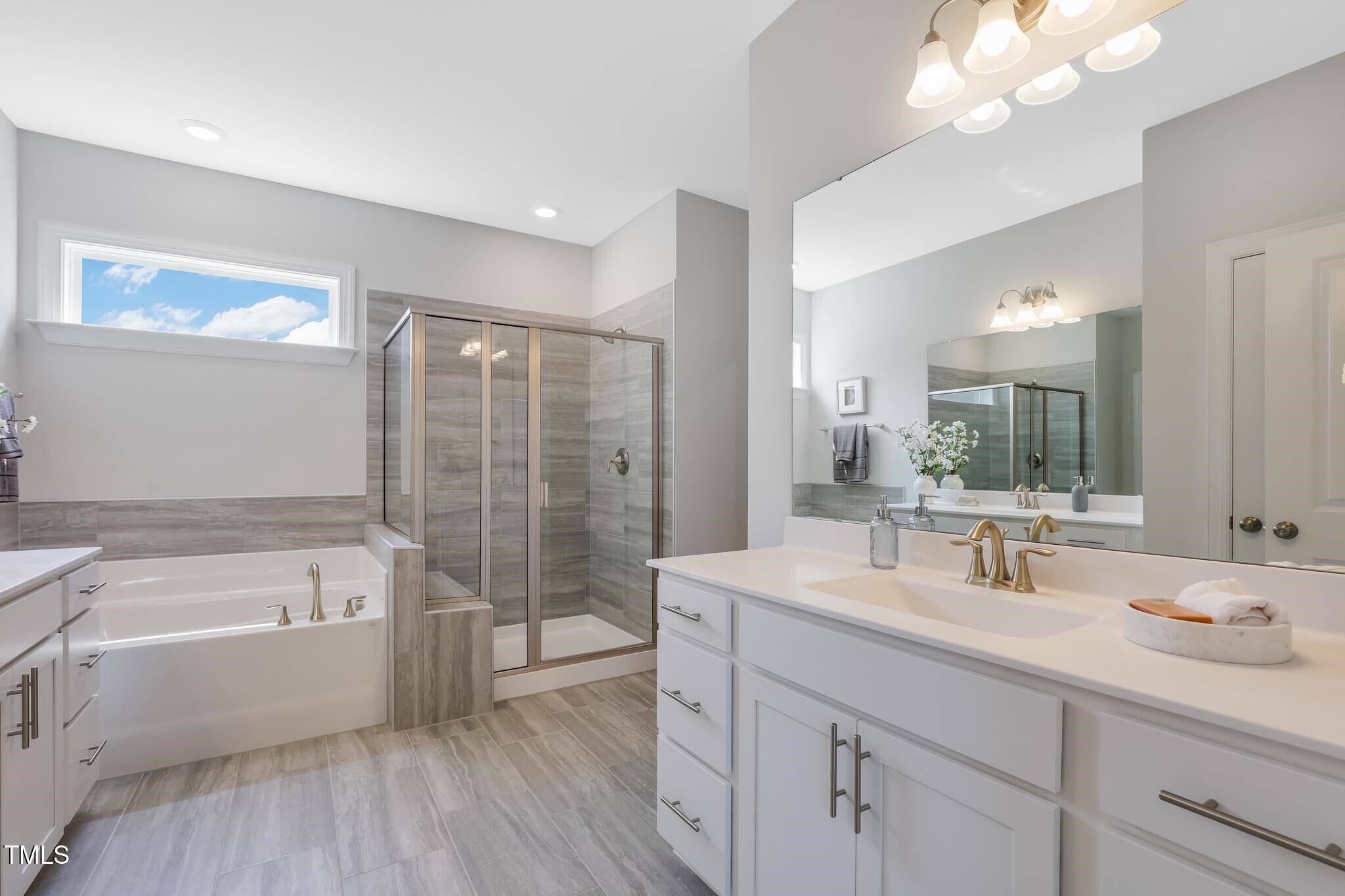 329 Calvander Lane Apex, NC 27539 - Photo 29 of 47 a bathroom with a tub a sink double vanity and mirror