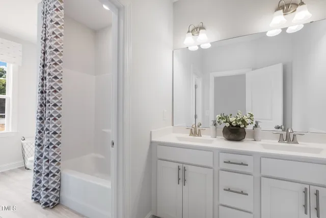 a bathroom with a sink a large mirror and a bathtub