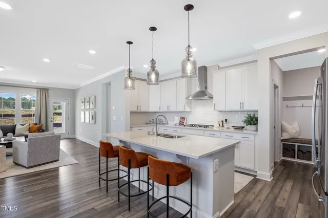 a large kitchen with sink a refrigerator and wooden floor