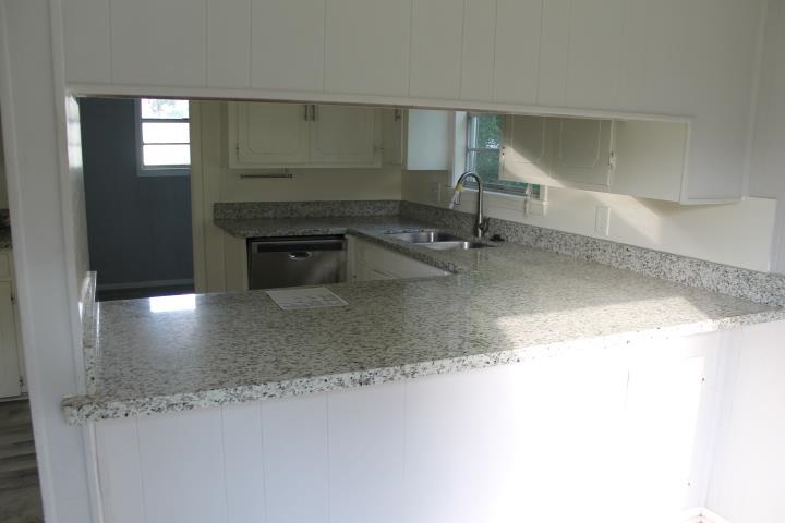 875 Woodrow Street Silsbee, TX 77656 - Photo 14 of 30 a kitchen with granite countertop a sink and a stove top oven