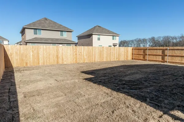 a view of a house with a yard and wooden fence