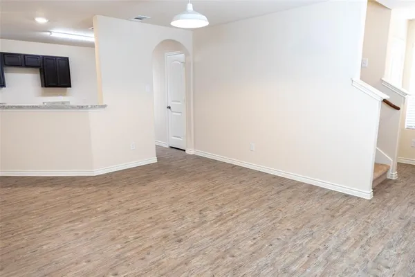 an empty room with wooden floor and mirror