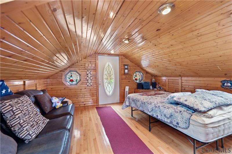 1073 New Berry Road Addison, PA 15411 - Photo 24 of 25 a spacious bedroom with a bed and a chandelier