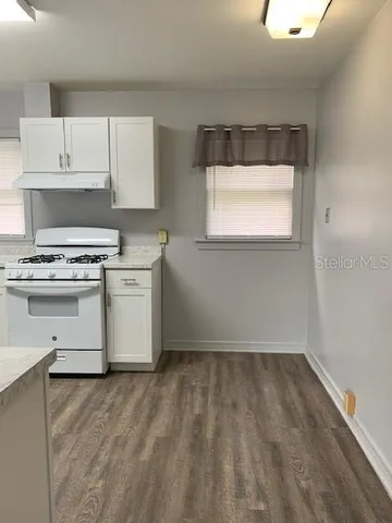 a kitchen with a stove a sink and a window