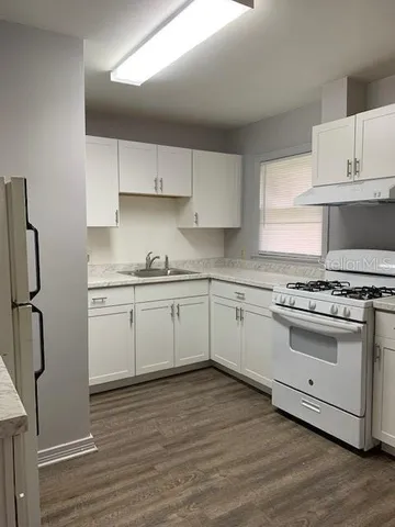 a white kitchen with a stove top oven
