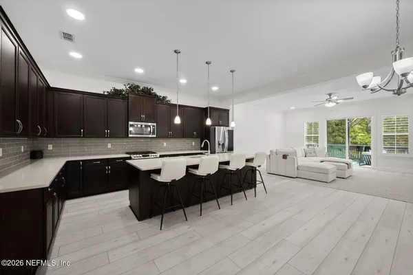 a living room with kitchen island furniture and a chandelier