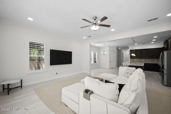 an empty room with a ceiling fan and windows