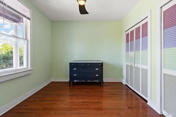 a view of a room with wooden floor and windows
