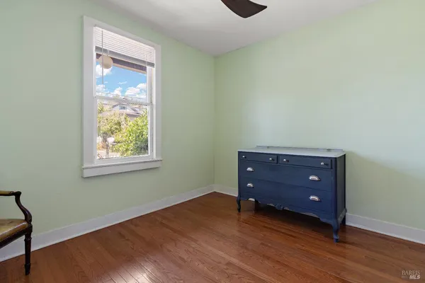 an empty room with a window and wooden floor