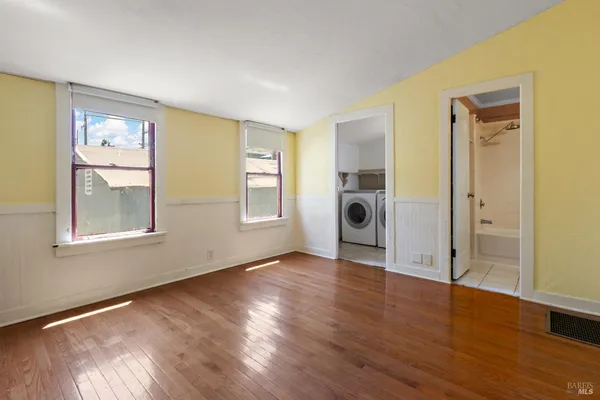 a view of a livingroom with wooden floor and a window