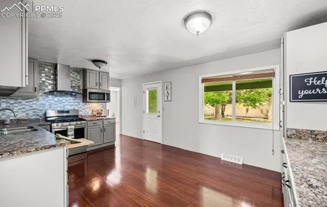 a kitchen with stainless steel appliances a stove top oven a sink and a refrigerator