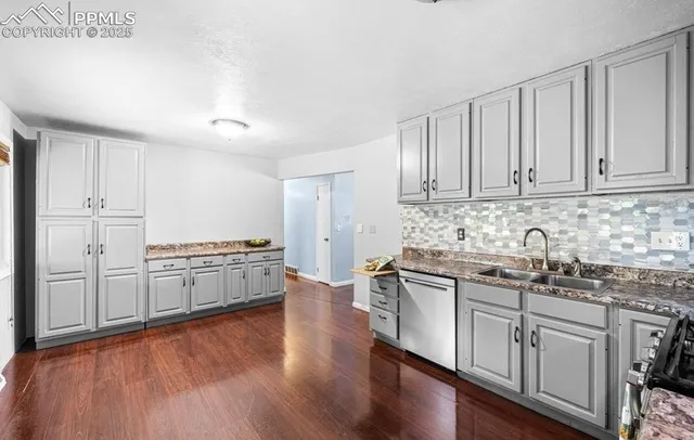 a kitchen with stainless steel appliances granite countertop a stove and white cabinets