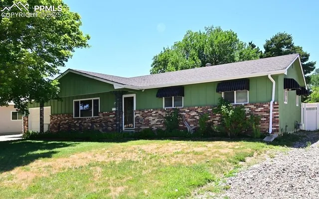 a front view of house with yard and trees around