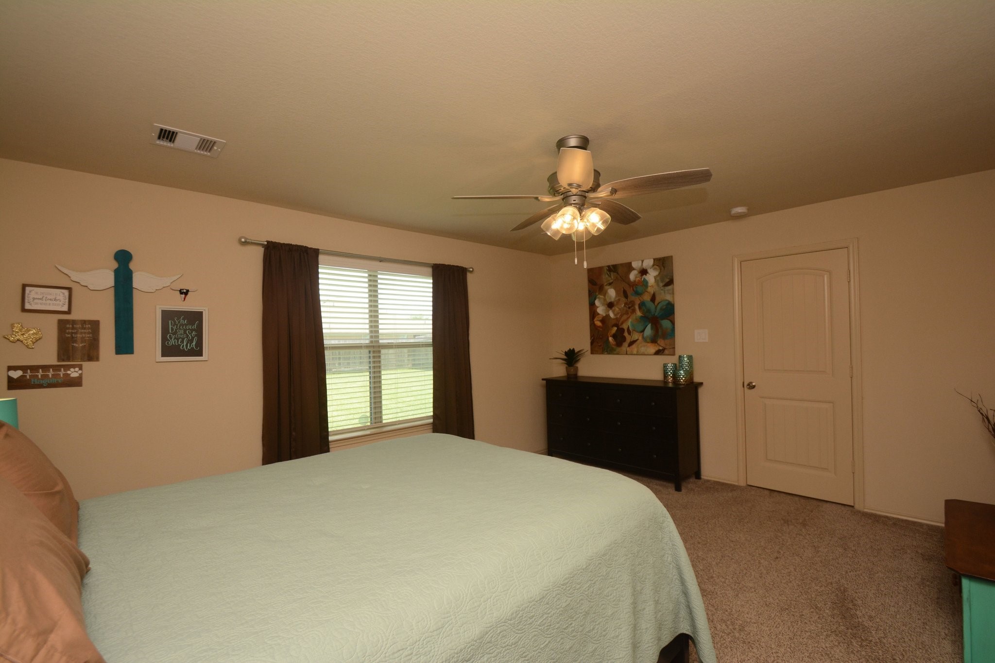 23318 Dukes Run Drive Spring, TX 77373 - Photo 26 of 41 This is a cozy bedroom featuring neutral walls, a ceiling fan, and carpeted flooring. It includes a large window, allowing natural light to fill the space.