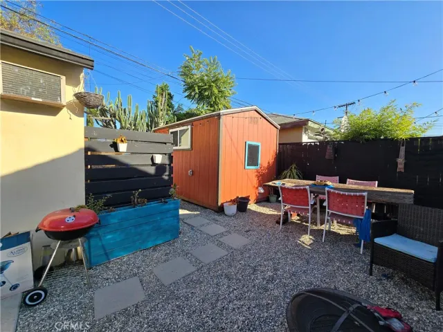 a view of a backyard with table and chairs potted plants and a couch