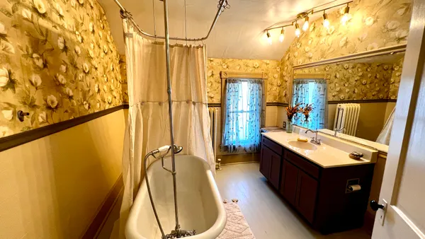 a bathroom with a sink and mirror with bathtub