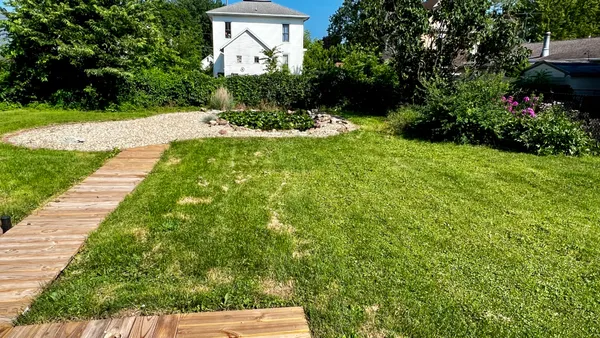 a view of a backyard with plants and a patio