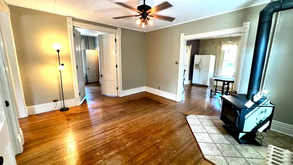 a living room with furniture a dining table and wooden floor