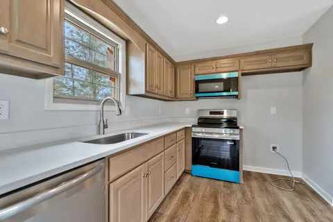 a kitchen with stainless steel appliances granite countertop a stove a sink and a microwave