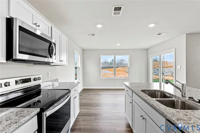 a kitchen with stainless steel appliances a stove sink microwave and cabinets