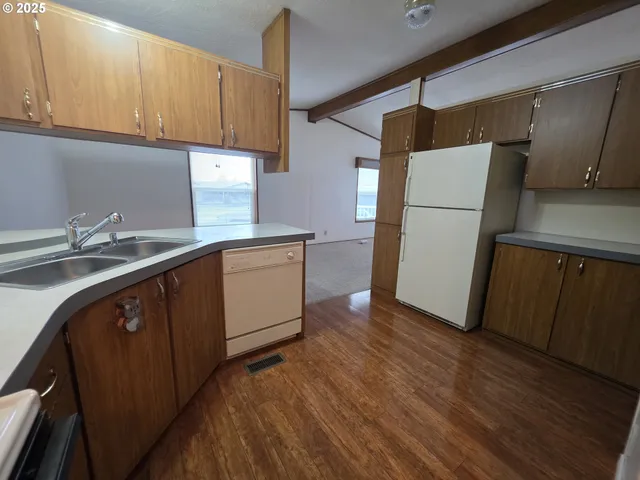 a kitchen with a sink a refrigerator and cabinets
