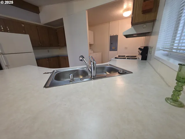 a kitchen with stainless steel appliances a sink a stove and a refrigerator