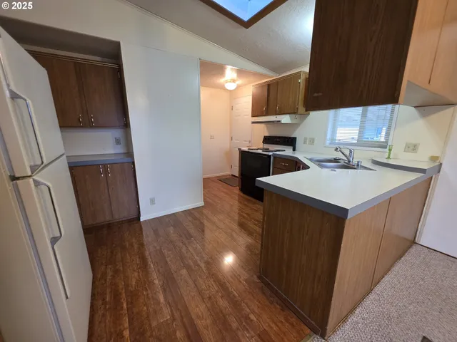 a kitchen with a sink a refrigerator a stove top oven a washer and dryer