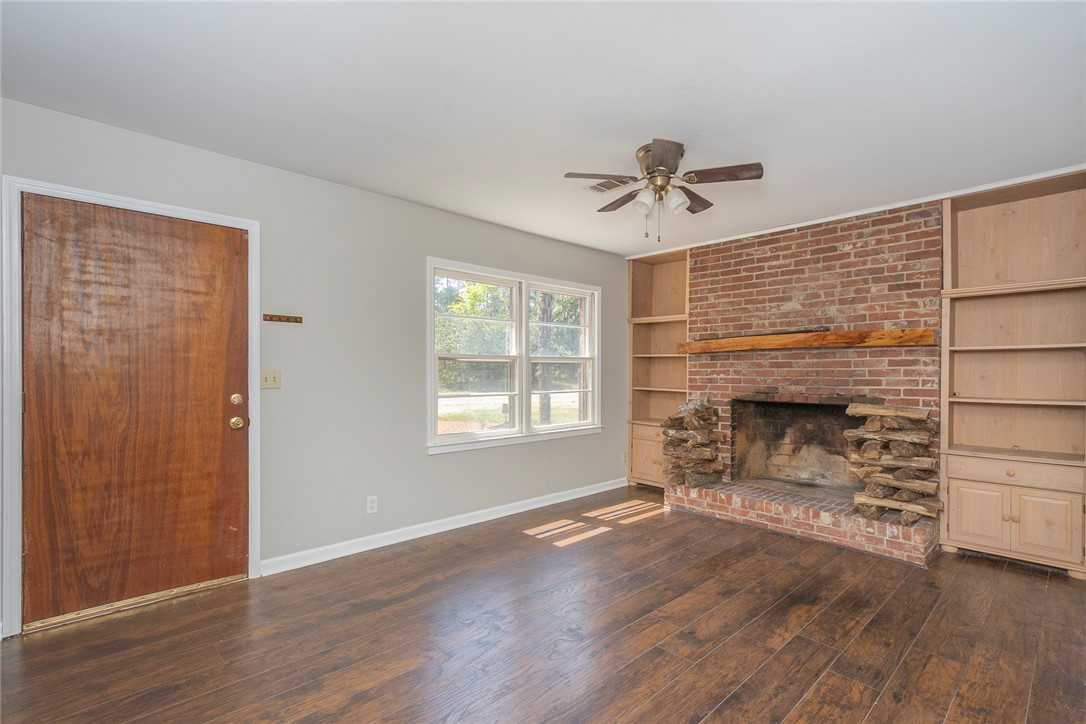 820 Travis Road Anderson, SC 29626 - Photo 13 of 46 This inviting living area features warm flooring and a prominent brick fireplace.