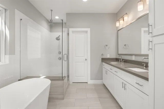 a spacious bathroom with a granite countertop sink a toilet a mirror and shower