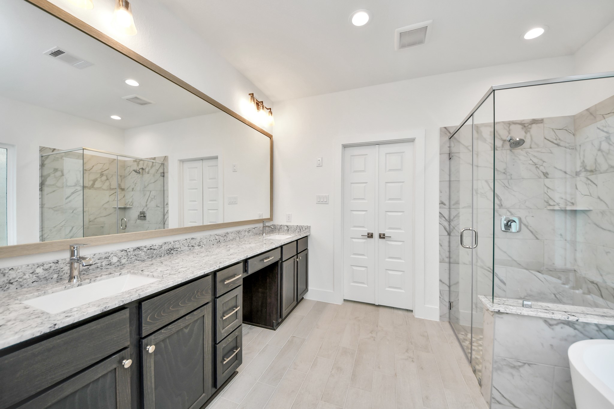 3106 Native Spg Drive Spring, TX 77373 - Photo 29 of 47 Elevate your daily routine at the elegant vanity, now equipped with double sinks, light countertops, modern hardware, and beautiful vanity lights.