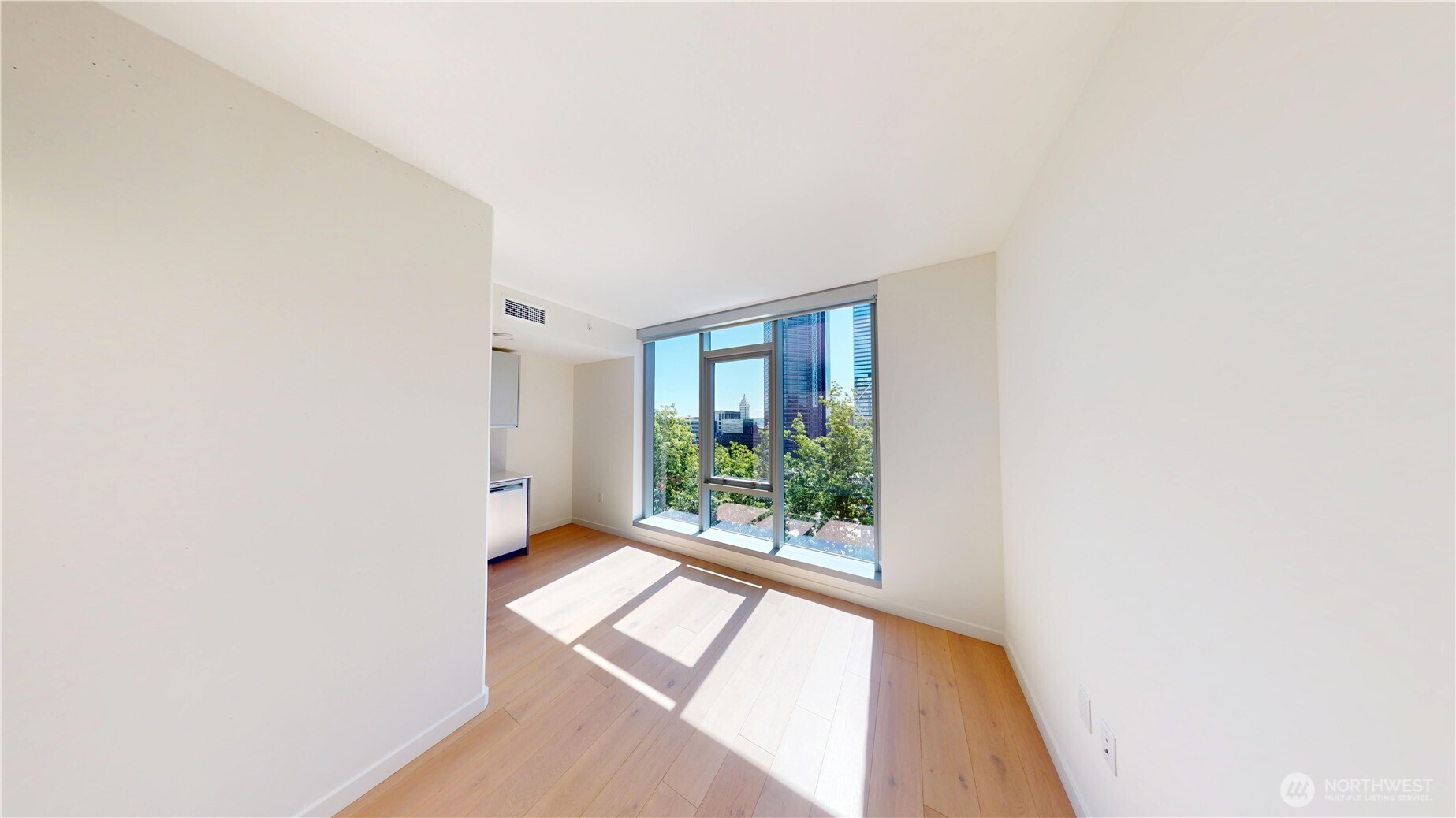 800 Columbia Street, Unit 702 Seattle, WA 98104 - Photo 13 of 15 a view of an empty room with wooden floor and a window