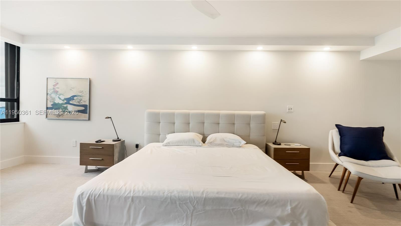 3 Grove Isle Drive, Unit C1407 Miami, FL 33133 - Photo 32 of 45 a bedroom with a bed and a chair