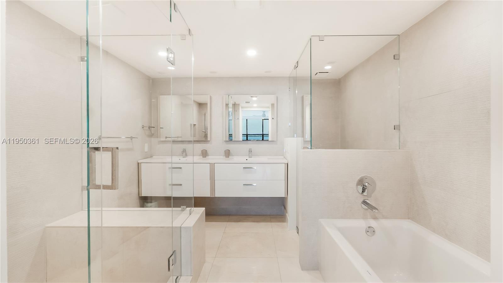 3 Grove Isle Drive, Unit C1407 Miami, FL 33133 - Photo 37 of 45 a bathroom with a bathtub a mirror a sink and vanity