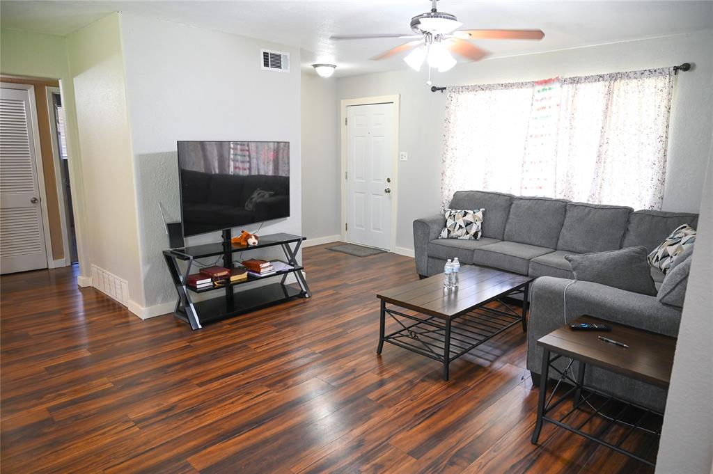 1352 Simpson Drive Hurst, TX 76053 - Photo 28 of 40 Living area featuring wood-finish flooring, light grey walls, and a ceiling fan with integrated lighting