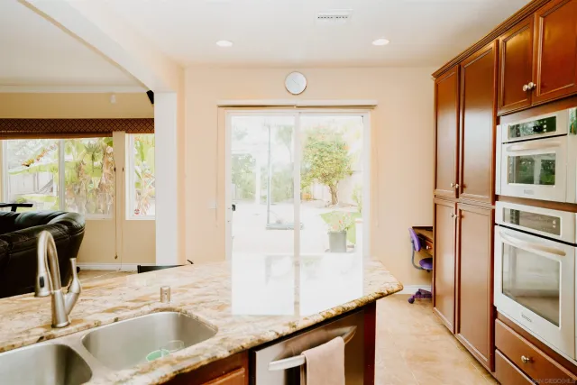 a kitchen with stainless steel appliances granite countertop a sink and a refrigerator