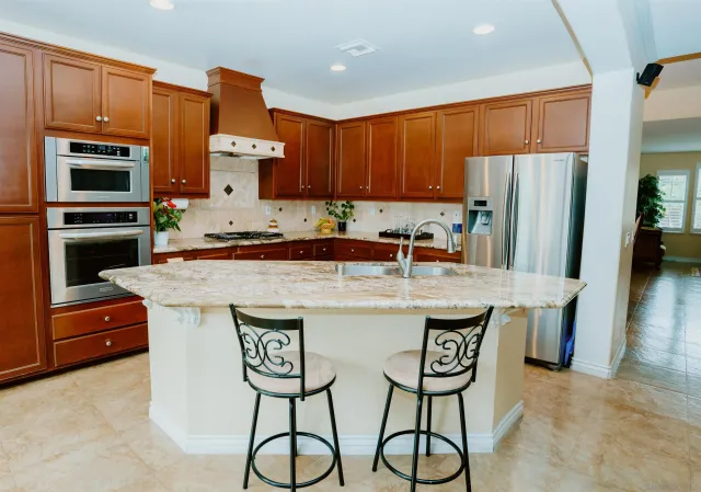 a kitchen with stainless steel appliances granite countertop a stove a refrigerator and a microwave