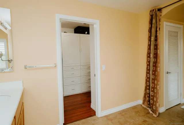 a view of walk in closet with wooden floor