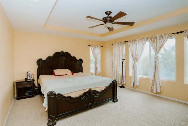 a bedroom with a bed and a large window