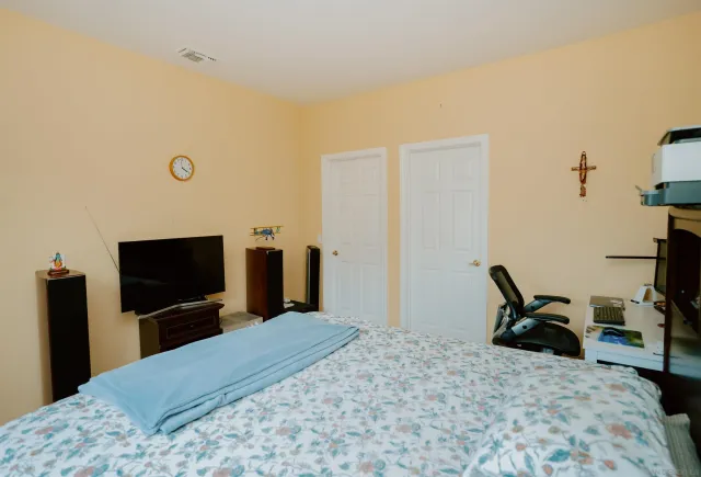 a bedroom with a bed and a flat screen tv