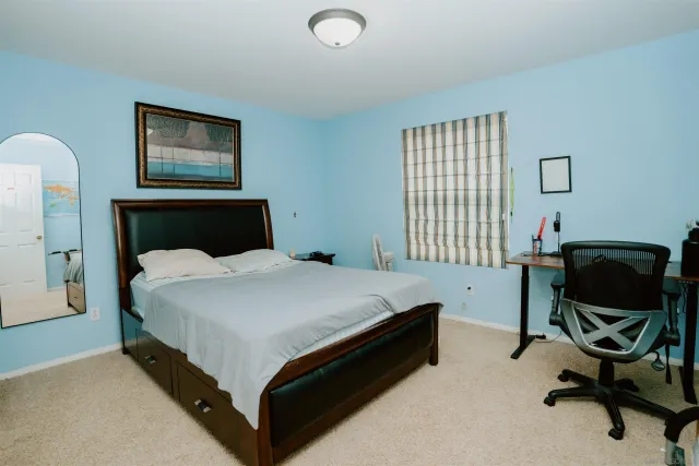 a bedroom with a bed chair and window