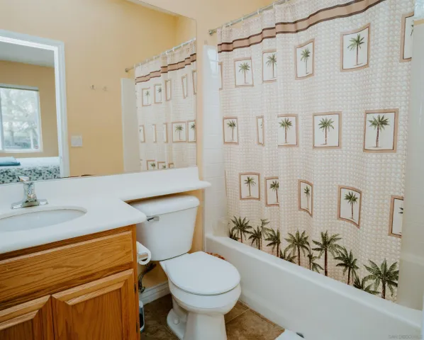 a bathroom with a granite countertop toilet sink and mirror